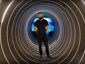 Lightspeed CEO Dax Dasilva stands in a tunnel made up of circles of light.