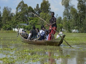A family uses a canoe after fleeing floodwaters that wreaked havoc in Ombaka Village, Kisumu, Kenya, April 17, 2024.