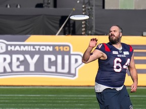 Alouettes offensive-lineman Sean Jamieson, wearing the team's blue jersey with red accents on the shoulders, is seen playing Frisbee on the field in Hamilton the day before last year's Grey Cup game.