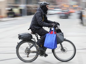 A food delivery courier rides an e-bike in Toronto