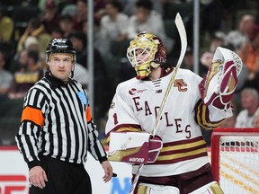 Boston College goaltender Jacob Fowler talks with a referee during a stop in the action.