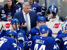 Fired Leafs head coach is seen behind the bench taking to his players during a timeout in their playoff series against the Bruins.