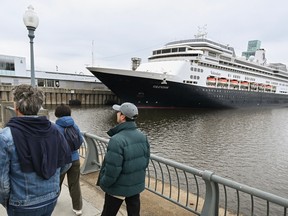 People walk by the Volendam cruise ship in the Port of Montrea