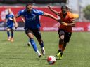 Forge FC forward Beni Badibanga (39) chases a ball with CF Montréal defender George Campbell (24) during second half Canadian Championship soccer action in Hamilton, Ont., Tuesday, May 7, 2024.