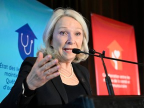 Sonia Bélanger gestures while speaking into a microphone on stage