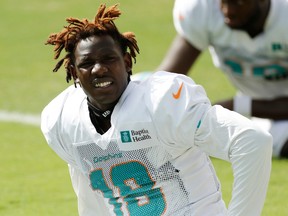 Preston Williams squints while he looks up during practice in a white Miami Dolphins jersey