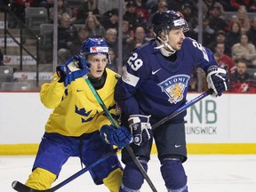 Sweden's Adam Engstrom and Finland's Niko Huuhtanen battle for position during first period IIHF World Junior Hockey Championship quarter-final hockey action in Moncton, N.B., on January 2, 2023.