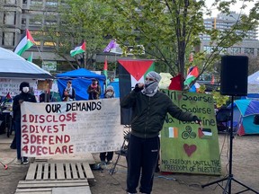 A pro-Palestinian protester warms up the media and dozens of supporters before a press conference at the encampment at McGill University