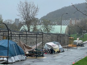 A view of some tents set up along teh fenceline on Duluth Ave. with Mount Royal seen in the background.