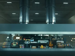 In this image taken from a video advertisement, a hydraulic press crushes an array of creative instruments.