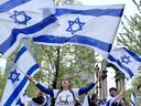 Marchers carry a huge Israeli flag down Union Ave. at the start of Israel Day celebration in Montreal Wednesday April 26, 2023.