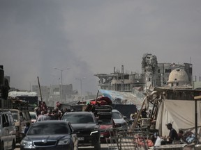 Palestinians fleeing with their belongings drive their vehicles in Khan Yunis city in the southern Gaza Strip on May 29, 2024.