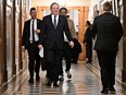 Quebec Premier François Legault walks down a corridor to a news conference.