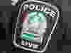 A police badge is seen on an arm.