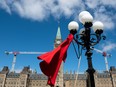 A red dress hangs on a light fixture on National Day of Awareness for the prevention of violence against Indigenous women, also known as the Red Dress Day in Ottawa, Friday, May 5, 2023.