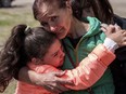 Khrystyna Pyimak, 11, hugs her mother Oksana Velychko, 42, after evacuation from Vovchansk, Ukraine, Sunday, May 12, 2024. Her husband was killed in their house after a Russian airstrike on the city.