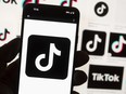 The TikTok logo is displayed on a mobile phone in front of a computer screen, Oct. 14, 2022, in Boston.