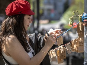 UBC student Sajedeh Zaki ties her tag onto a message line at the pro-Palestinian encampment on the McGill University campus in Montreal on Friday May 10, 2024. Dave Sidaway / Montreal Gazette