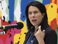 Valérie Plante speaks at a press conference with a colourful wall behind her.