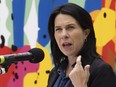 Valérie Plante speaks at a microphone with a colourful background