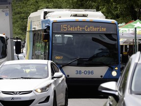 An STM bus labelled 15 Sainte-Catherine drives among cars on a downtown street
