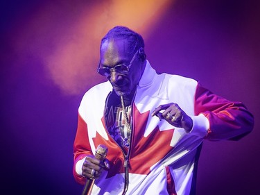 Snoop Dogg, wearing a partially zipped Canadian flag jacket, dances during his concert