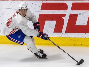 Canadiens prospect Filip Mesar is seen in a white jersey with the puck on his stick extended in front of him.