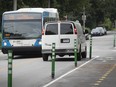 The 129 bus makes its way along Bourret Ave. while a minivan drives close to the bike path