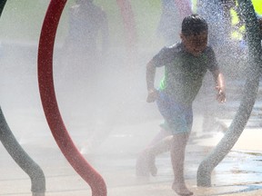 A boy runs through a fountain on a summer day