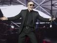 Performer Pitbull spreads his hands and wears sunglasses performing at the Bell Centre in Montreal
