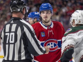 Canadiens' Kirby Dach listens to linesman Derek Nansen, left, in the face-off circle.