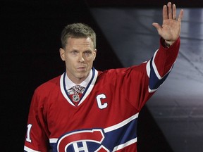Former Canadiens captain Saku Koivu waves to fans i Montreal while wearing a red Canadiens jersey