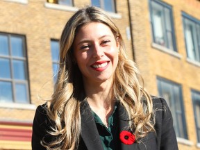Maude Marquis-Bissonnette smiles while wearing a coat and poppy outside a building