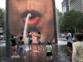 People cool off at Crown Fountain in Millennium Park as temperatures reached a record high of 97 degrees Fahrenheit on June 17, 2024 in Chicago, Illinois.
