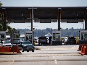 A Canada Border Services Agency officer is silhouetted as motorists enter Canada at the Douglas-Peace Arch border crossing, in Surrey, B.C., on Monday, Aug. 9, 2021.