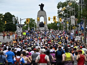 Runners make their way toward the National War Memorial at the start of the marathon of the Ottawa Race Weekend in Ottawa, Sunday, May 26, 2024.