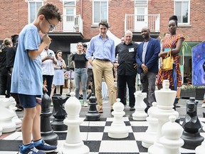 Prime Minister Justin Trudeau looks on as a boy ponders his next chess move during a 2023 St-Jean-Baptiste event in Montreal. Trudeau may just spend this summer contemplating his next move too, writes Robert Libman.