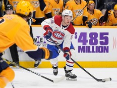 Canadiens defenceman Jordan Harris, in the Habs' white jersey, passes the puck to a teammate whiel a Predators player, in yellow, defends during a game in Nashville in March.