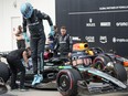 Mercedes driver George Russell of Great Britain jumps out of his race car