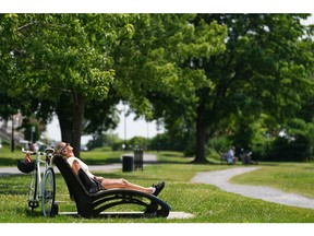A woman reclines on a chair, soaking in the sun in a park along the waterfront in Montreal's LaSalle borough on Tuesday.