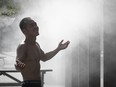 A man uses a misting fountain to cool off during a heat wave