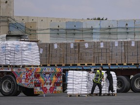 Trucks carrying humanitarian aid for the Gaza Strip pass through the inspection area at the Kerem Shalom Crossing in southern Israel, Thursday, March 14, 2024.
