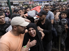 Mourners carry the body of Samer Rumaneh, draped in a Palestinian flag, who was killed in an Israeli military raid, during his funeral in the West Bank city of Nablus, on May 12, 2024.