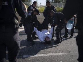 Israeli police officers remove an ultra-Orthodox Jewish man from the street during a protest against army recruitment in Jerusalem on June 2, 2024.