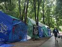 A man walks by an encampment at Victoria Square on Sunday, June 23, 2024, set up by Members of the Divest for Palestine Collective.