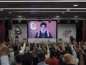Supporters of the Iranian-backed Hezbollah group listen to a speech by Hezbollah leader Sayyed Hassan Nasrallah speaking via a video link, in the southern suburbs of Beirut, Lebanon, Tuesday, May 14, 2024.