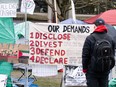 A sign outside an encampment says, OUR DEMANDS Disclose Divest Defend Declare