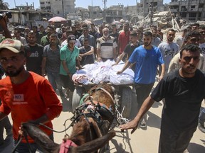Palestinians transport the bodies of loved ones killed during Israeli bombardment for burial in al-Tuffah neighbourhood in Gaza City on June 22, 2024, amid the ongoing conflict between Israel and the militant group Hamas.