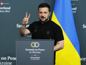 Ukraine's President Volodymyr Zelenskyy flashes a V sign as he addresses Ukraine's closing press conference of the Summit on peace in Ukraine, at the luxury Burgenstock resort, near Lucerne, on June 16, 2024.