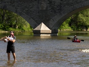 People cool off along the Humber River in Toronto on Monday, May 29, 2023.